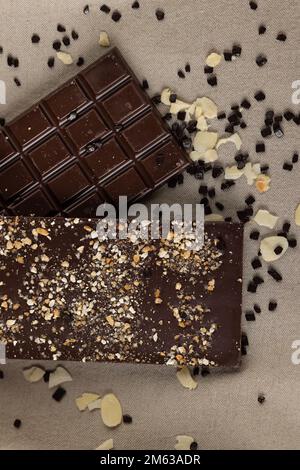 Top view of chocolate bars with diverse nuts over brown tablecloth Stock Photo