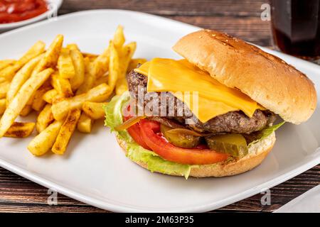 Cheeseburger with Tomatoes and Pickles with French Fries and Ketchup Stock Photo