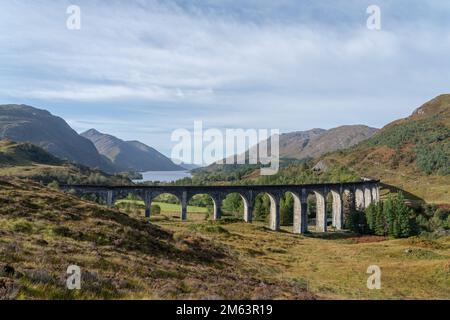 Glenfinnan Railway Viaduct in the Scottish Highlands, Scotland. famous arched viaduct used by steam trains in the mountains. Aerial view with loch Stock Photo