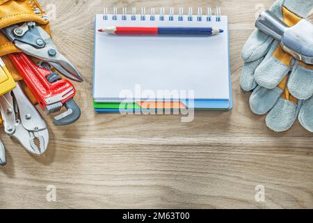 Construction tooling tool belt safety gloves claw hammer notepad pencil. Stock Photo