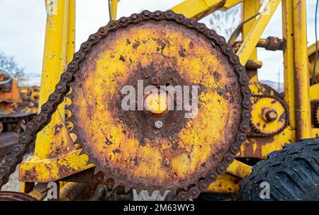 Detail of rusty gear and chain on an antique tractor Stock Photo