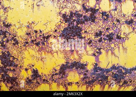 Rust and peeling yellow paint on the surface of an antique tractor Stock Photo