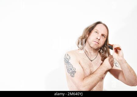 Man combing his long hair Stock Photo