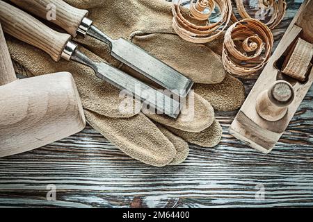 Leather protective gloves lump hammer flat chisels shaving plane planning chips. Stock Photo