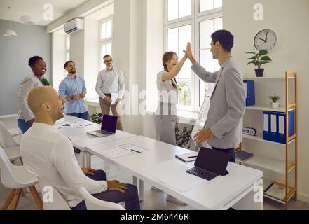 Success and winning concept - happy business team giving high five in office Stock Photo