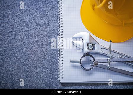 Notebook building helmet compasses adjustable spanner construction concept. Stock Photo