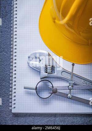 Notebook building helmet compasses adjustable wrench construction concept. Stock Photo