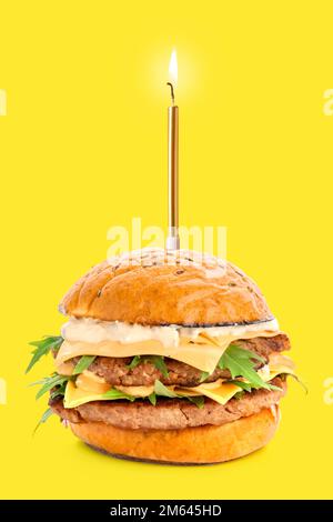 Tasty cheeseburger with burning Birthday candle on yellow background Stock Photo