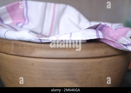 Vintage ceramic bowl, brown bowl. A kitchen towel on the bowl. side view Stock Photo