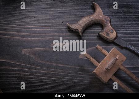 Rusty hand saw marking gauge on wooden board copy space. Stock Photo