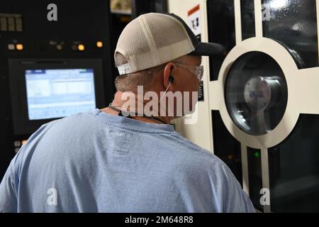 Philip Trauth, 573rd CMXS machinist, monitors a Makino T-4 5-axis computer numerical control milling machine as it manufactures an F-15 aircraft center shoulder wing rib at Robins Air Force Base, Georgia, March 30, 2022. During the manufacturing process, a forging piece of aluminum is used to machine the center shoulder wing rib and takes approximately 22 hours complete. C-130H propeller,Taper bore,computer numerical control,machinist, Stock Photo