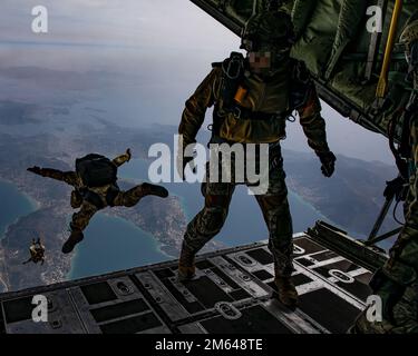 Members of Greek Special Forces (SOF) prepare for Exercise Orion as they jump from the ramp of a Greek Air Force C-130 aircraft during airborne operation over a coastal area near Elefsina, Greece, March 30, 2022. Exercise Orion reinforces Greece as a regional SOF leader, enhances interoperability across multiple domains, and strengthens relationships with NATO and non-NATO partners. The exercise focuses on highlighting operational capabilities, international collaborations and conventional and hybrid warfare training. Stock Photo