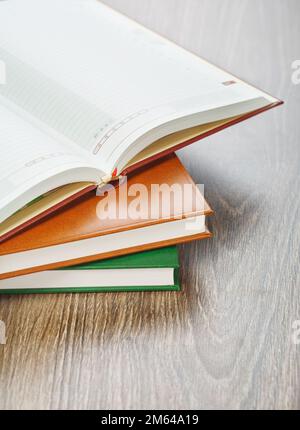 three notebooks on wooden background Stock Photo