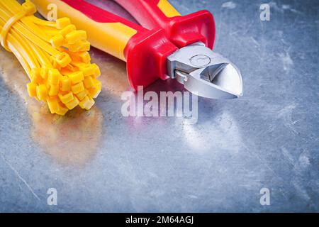 Wire-cutter cable ties on metallic background construction concept. Stock Photo
