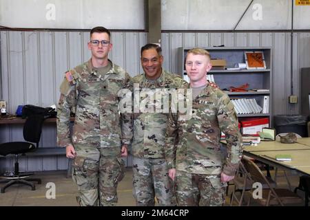 Gen. Michael Garrett, Commander of U.S. Army Forces Command, center, poses for a photo with Spc. Elijah Tenbrink, left, an information technology specialist assigned to 3rd Battalion, 67th Armor Regiment, and Spc. Jarrod Frazier, an inteligence anaylst assigned to 6th squadron, 8th Cavalry Regiment, after awarding them both with challange coins for their hard work and expertise with the On-The-Move pilot during his visit to see the modernization progress of the 'Spartan Brigade,' 2nd Armored Combat Team, 3rd Infantry Division on Fort Stewart, Georgia, March 31, 2022. The Spartan Brigade is the Stock Photo