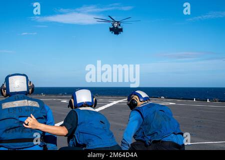 Sailors assigned to the forward-deployed amphibious dock landing ship USS Ashland (LSD 48) standby for a CH-53E Super Stallion helicopter assigned to Marine Heavy Helicopter Squadron 466 (HMH-466) to land on the flight deck during Balikatan 22, off the coast of the Philippines, March 31, 2022. Balikatan is an annual exercise between the Armed Forces of the Philippines and U.S. military designed to strengthen bilateral interoperability, capabilities, trust, and cooperation built over decades shared experiences. Balikatan, Tagalog for 'shoulder-to-shoulder,' is a longstanding bilateral exercise Stock Photo