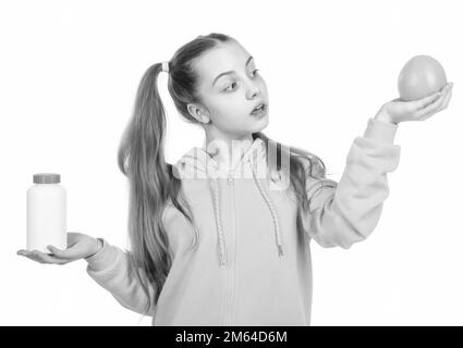 choice between natural products and pills. presenting vitamin product. child with orange pill. Stock Photo