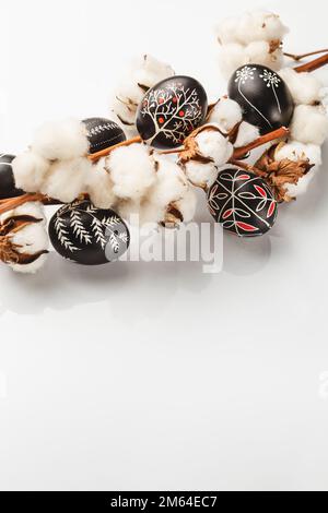 Black and White Pysanka Easter Eggs Decorated with Traditional Eastern European Beeswax Technique and a Branch of Cotton Flower. Greeting Card with Sp Stock Photo