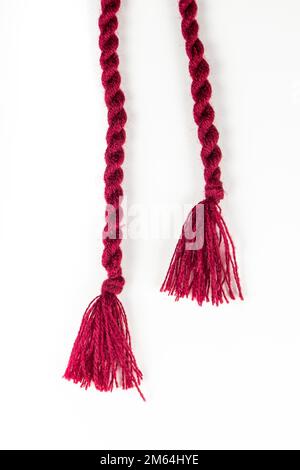 Burgundy tassels for a knitted dress on a white background. Stock Photo