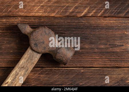 Old and rusty iron hummer on wooden background. Stock Photo