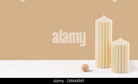 Handmade olive wax pillar candle on a neutral pastel and white background. Sustainability vegan candle, natural materials. Minimalistic, cozy atmosphe Stock Photo