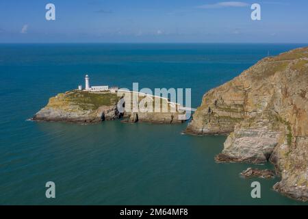 Panoramic photo of South Stack Lighthouse near Holyhead Anglesey aerial taken from out at sea showing the island and rocky cliffs Stock Photo