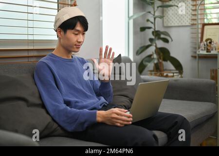 Young asian man making video call to friends or relatives, enjoying pleasant conversation Stock Photo