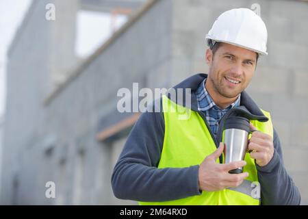 cheerful architect in helmet with cup of coffee Stock Photo