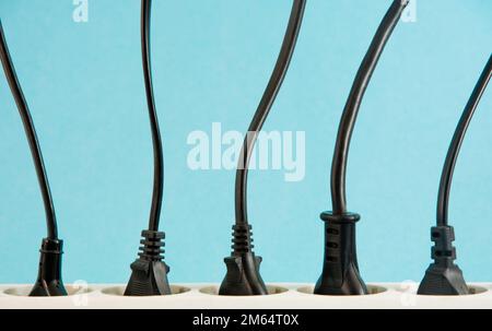 White extension cord with three plugs on blue background. Stock Photo