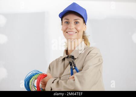 happy female electrician fixing electricity problem Stock Photo