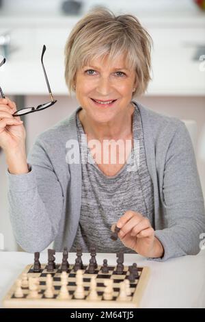 mature woman playing chess at home Stock Photo