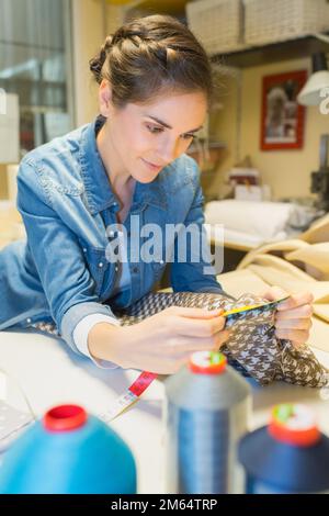 young tailor woman doing needlework Stock Photo
