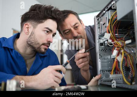 technician fitting component into computer Stock Photo