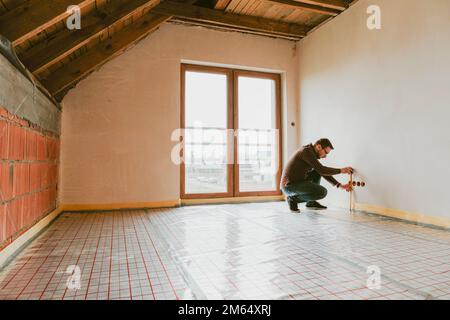 Builder measuring wall with tape Stock Photo