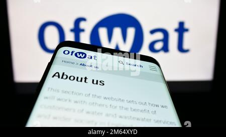 Smartphone with webpage of Water Services Regulation Authority (Ofwat) on screen in front of logo. Focus on top-left of phone display. Stock Photo