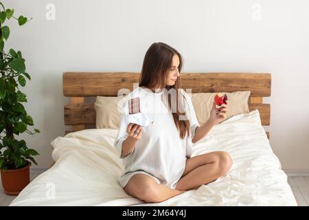 Cute pregnant woman choosing what to eat Stock Photo