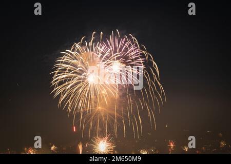 Series of real fireworks against black sky at night. Pyrotechnics exploding, celebrating the coming of the New Year. Stock Photo