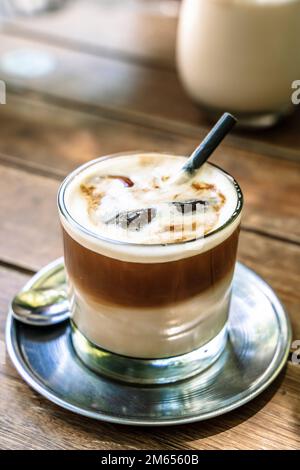 Cold coffe latte with milk in glass on city cafe table. Summer ice drinks. High quality photo Stock Photo