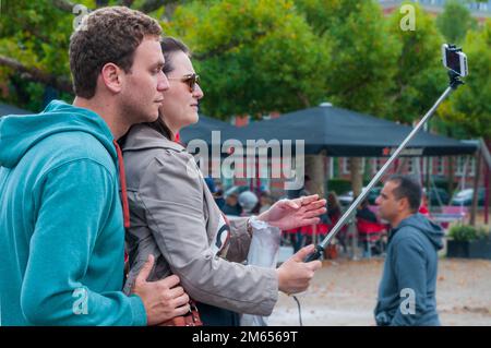 Tourists taking selfies on selfie sticks. Stock Photo