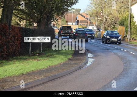 Road leading into the Lincolnshire village of Heckington, cars are driving in and out of the village. Stock Photo