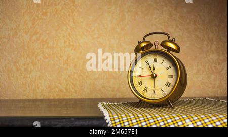 Retro alarm clock with five minutes to twelve o'clock. Old style filtered photo Stock Photo