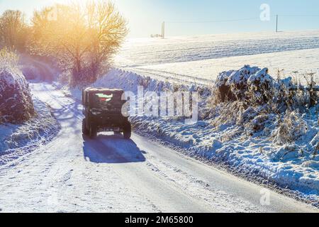 A Ranger quad bike on a snow covered lane near the Cotswold village of Birdlip, Gloucestershire, England UK Stock Photo