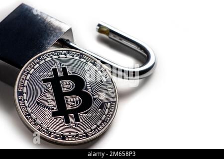 Digital currency, silver bitcoin with open padlock on white. Stock Photo