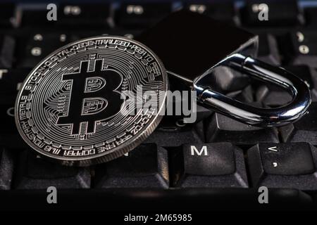 Cryptocurrency bitcoin with lock on keyboard. Bitcoin security. Stock Photo
