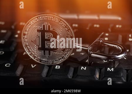 Cryptocurrency bitcoin with lock on keyboard. Bitcoin security. Stock Photo