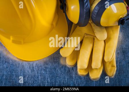 Composition of safety workwear on scratched metallic background construction concept. Stock Photo