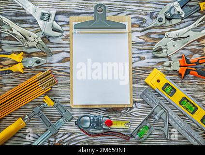 Clipboard construction tools on wooden board. Stock Photo