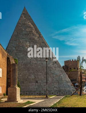 The Roman tomb in the shape of a Pyramid, Pyramid of Caius Cestius, and Porta San Paolo, access to the ancient Aurelian walls. Rome, Lazio, Italy, Stock Photo