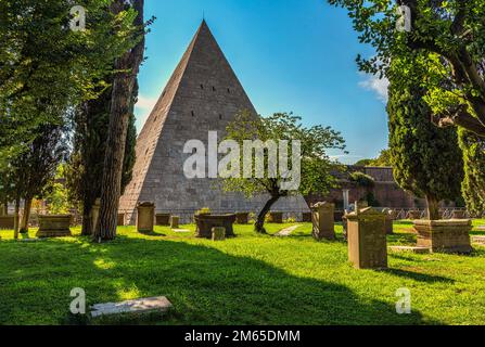 The Pyramid of Cestius is a Roman tomb in the shape of a pyramid and is incorporated into the rear perimeter of the non-Catholic cemetery. Rome, Lazio Stock Photo