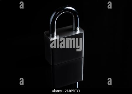 Steel padlock on the black textured background. Stock Photo